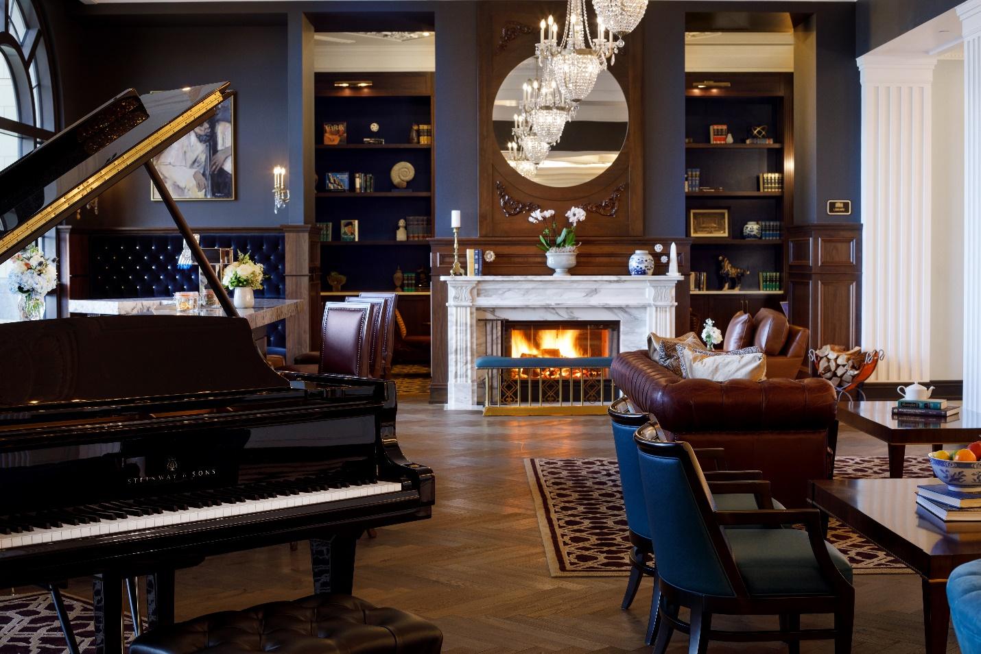 Hotel Carmichael interior den area with fireplace, piano and seating